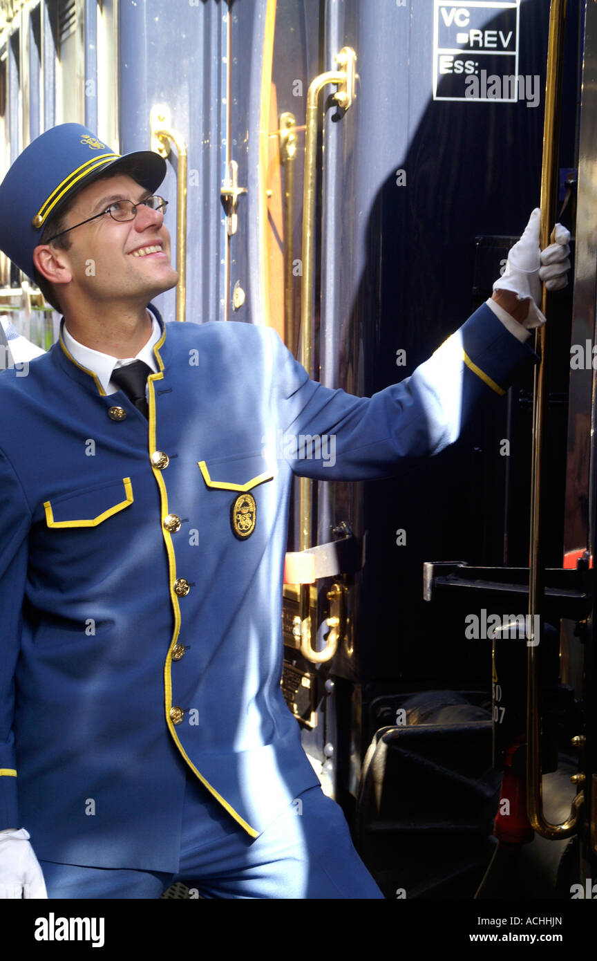 Orient Express luxury train and uniformed steward happy smiling entering train. Stock Photo