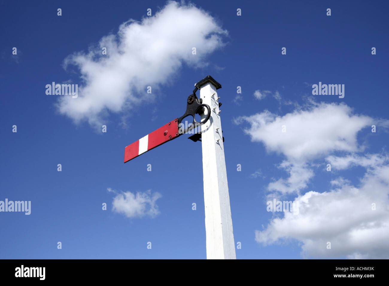 Red and white railway signal in a blue sky Stock Photo