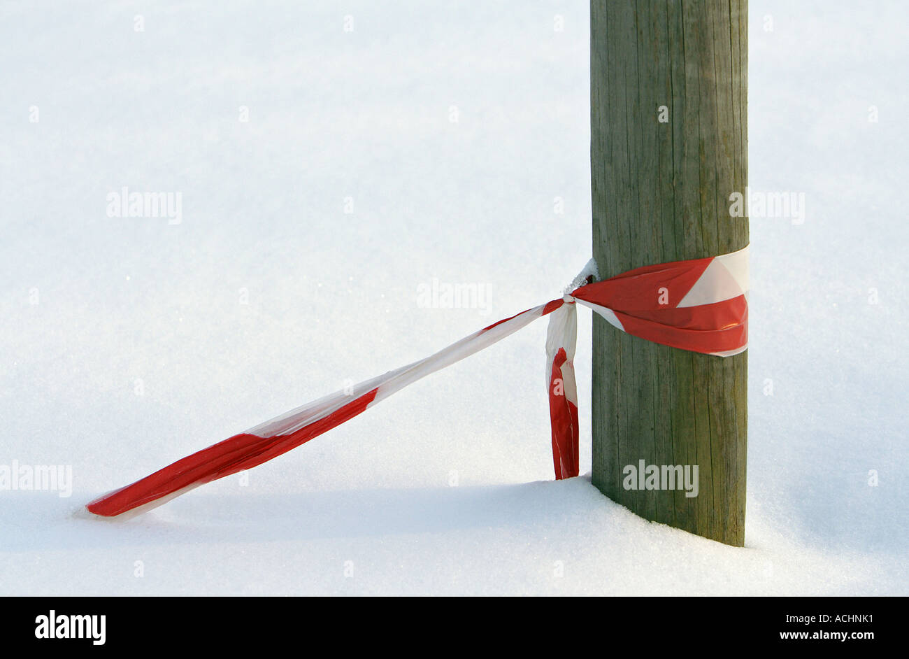 Pillar and red and blue barrier tape sunken in in snow Stock Photo