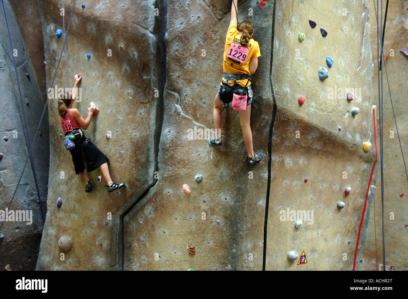 Young women climbing a wall at indoor climbing facility at a climbing