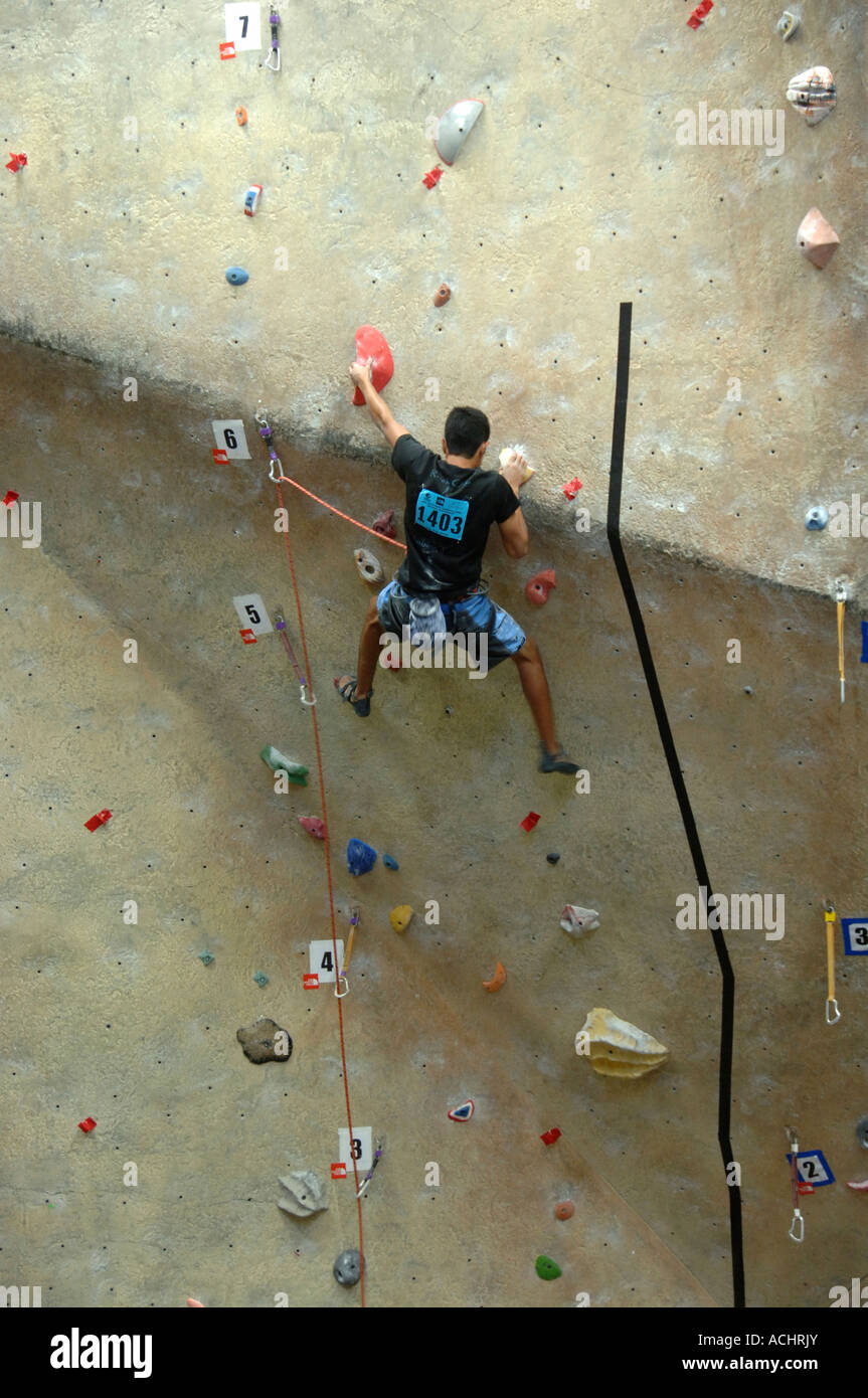 Young man climbing a wall at indoor climbing facility at a climbing
