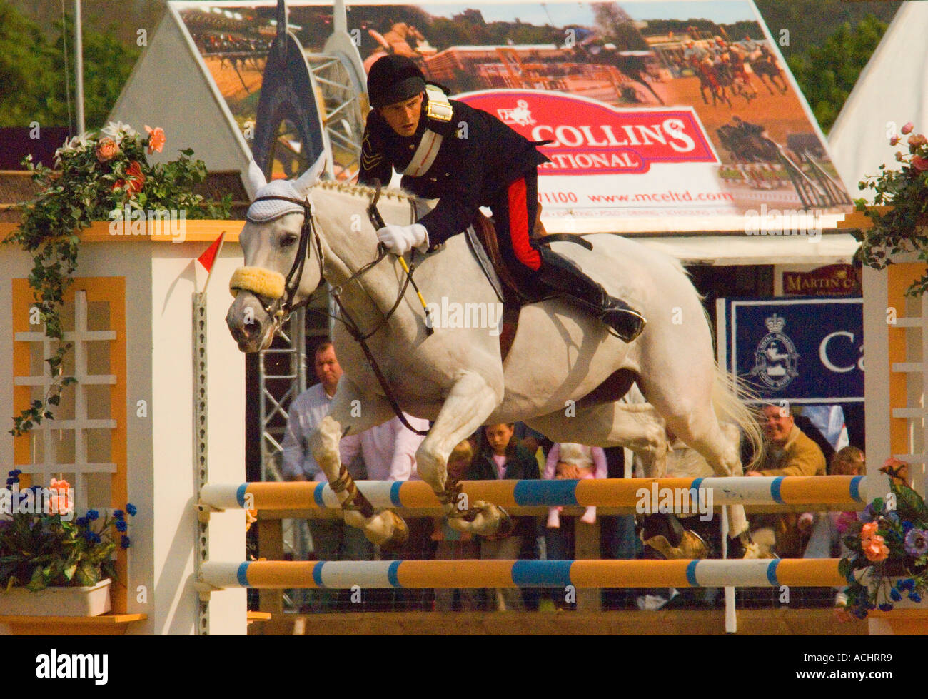 White horseclearing an obstacle at show jumping competition Royal Windsor Horse Show 2006 Stock Photo