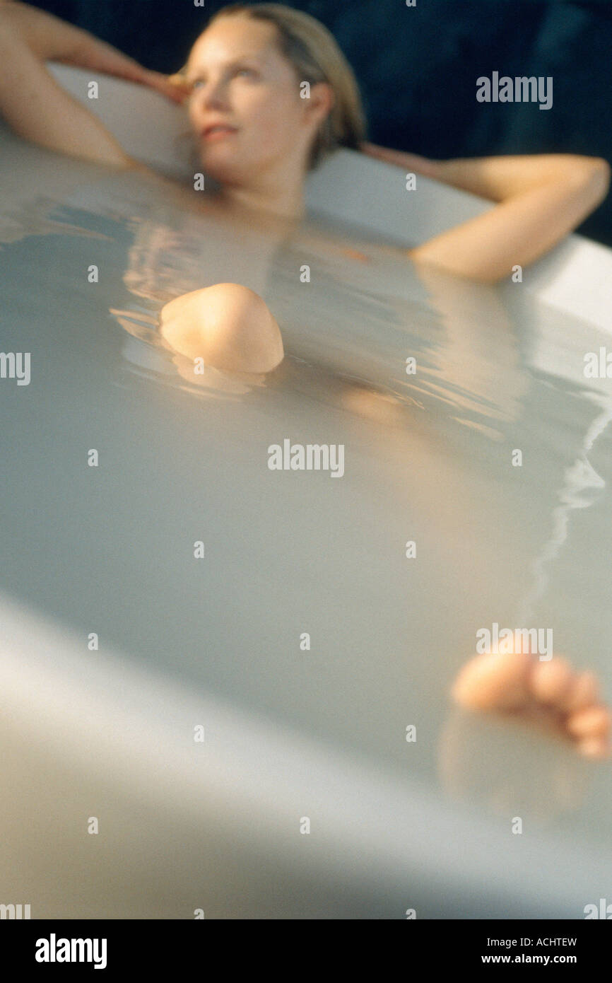 Woman lying down in bathtub Stock Photo