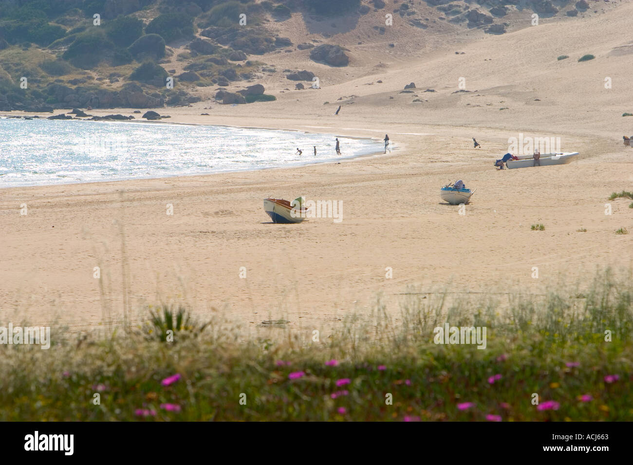 People and boats on the Andalucian beach of Bolonia Spain Stock Photo