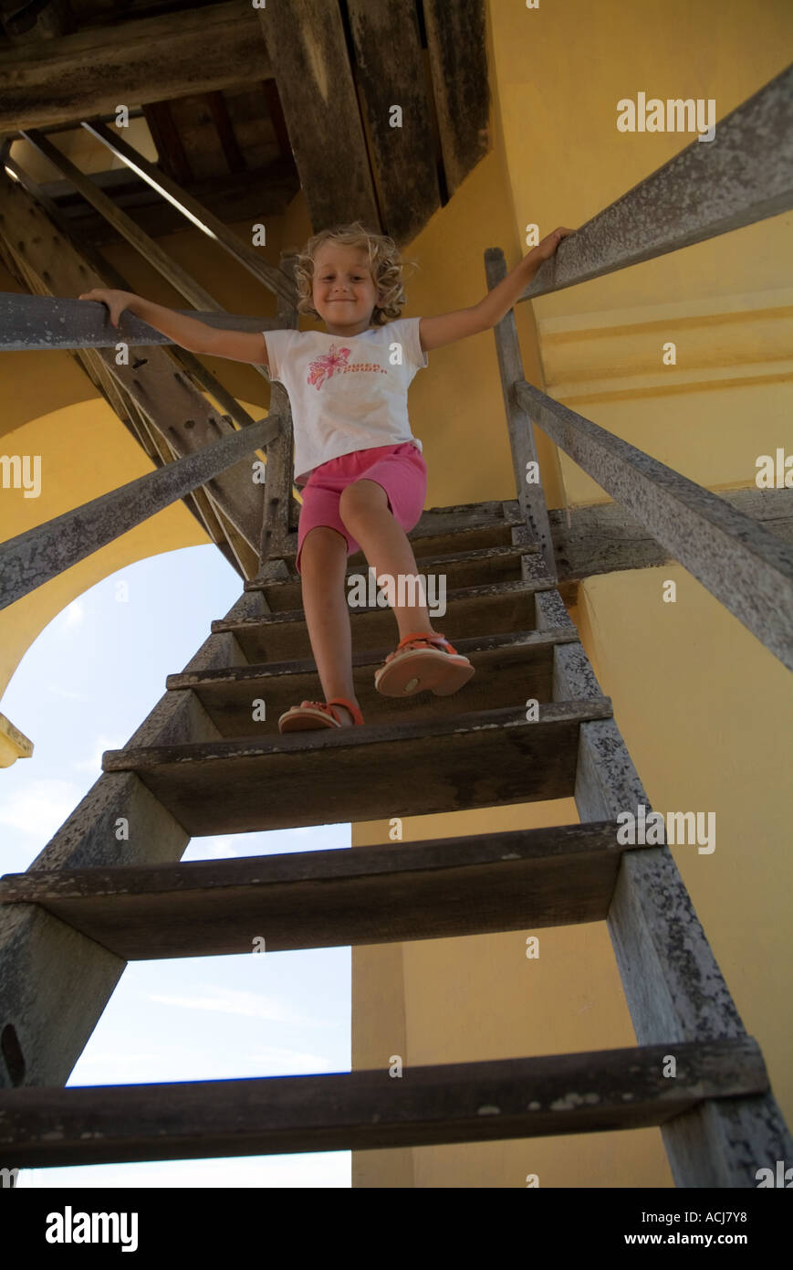 Little girl going down wooden stairs inside the tower of Manaca-Iznaga estate, Cuba. Stock Photo