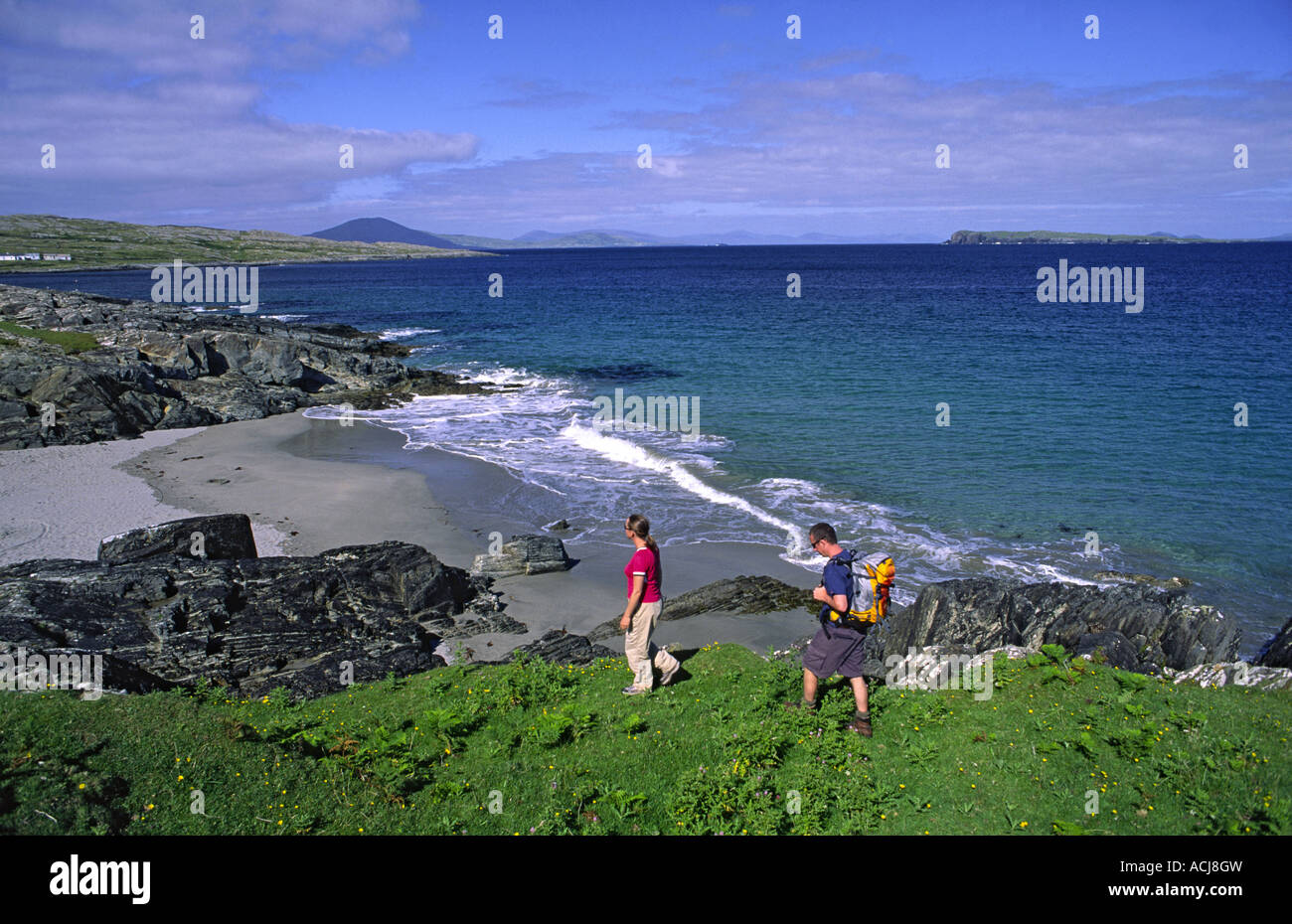 Summer coastal walkers beside Tranaun beach, on Inishturk Island, County Mayo, Ireland. Stock Photo