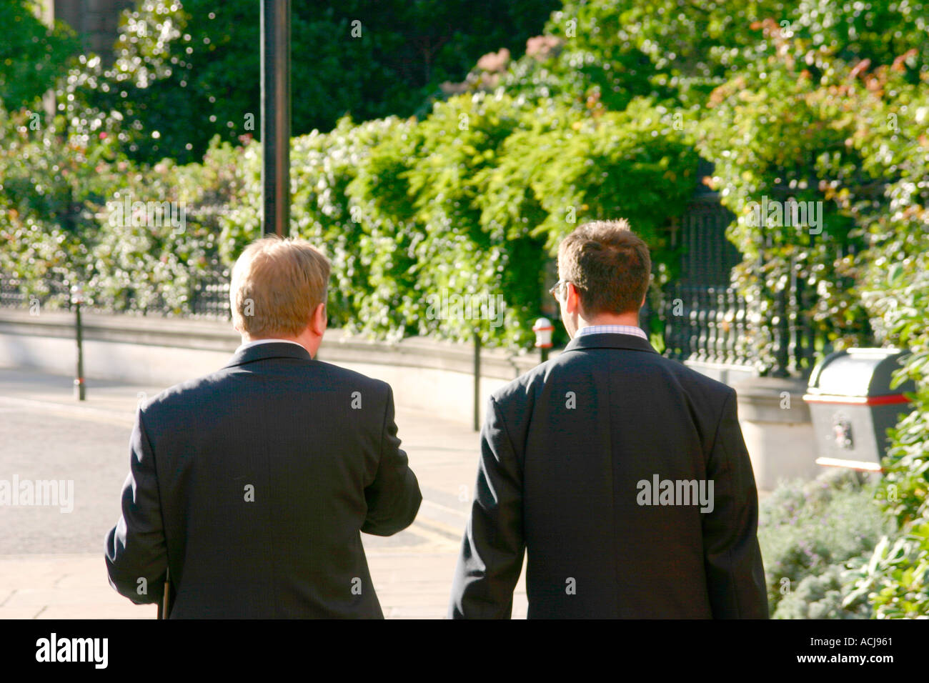 Two business men walking and talking Stock Photo - Alamy