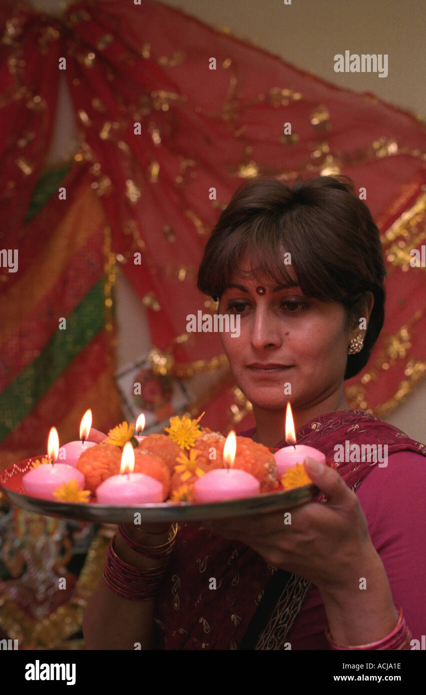Asian lady holding a plate of traditional Indian sweets, Middlesex, UK. Stock Photo