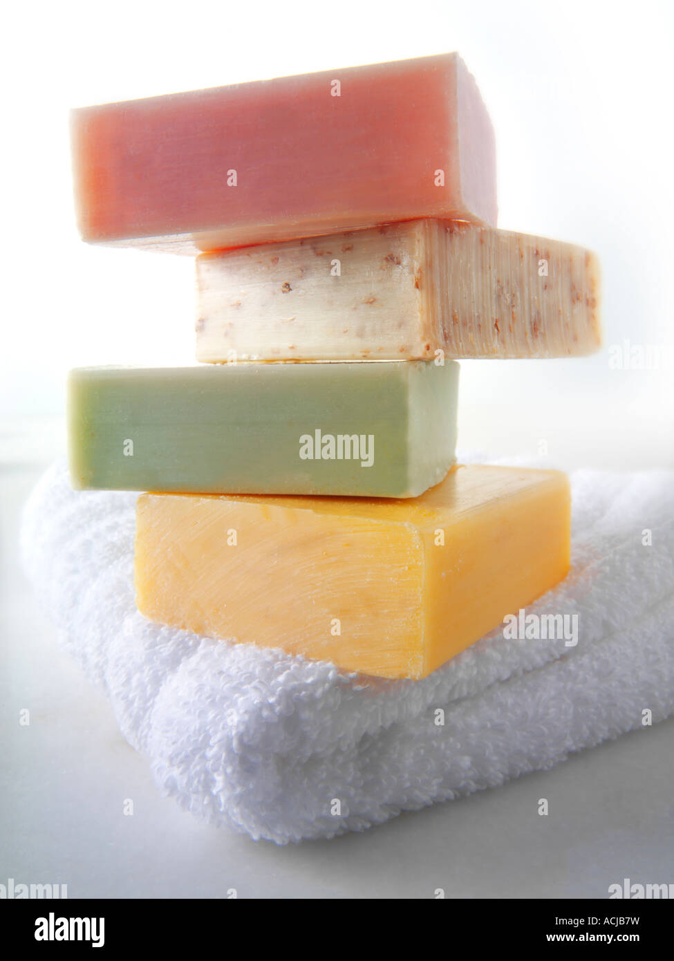 4 bars of hand made natural scented soap bars piled up on a white face towel Stock Photo