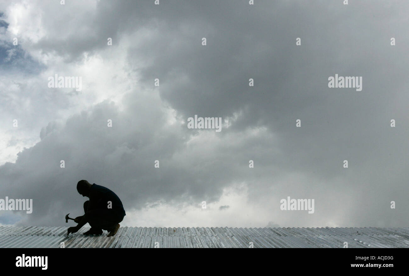 Man works on roof Uganda Stock Photo Alamy
