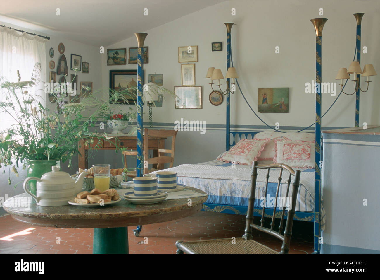 Bedroom bed with blue and golden pillars breakfast on table flowers Stock Photo Alamy