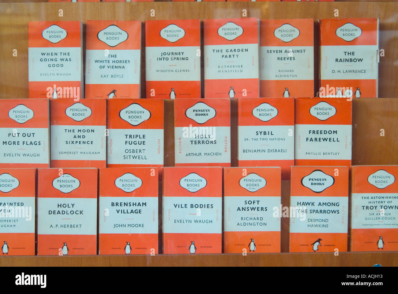 Display of old orange covered Penguin books in secondhand bookshop window Stock Photo