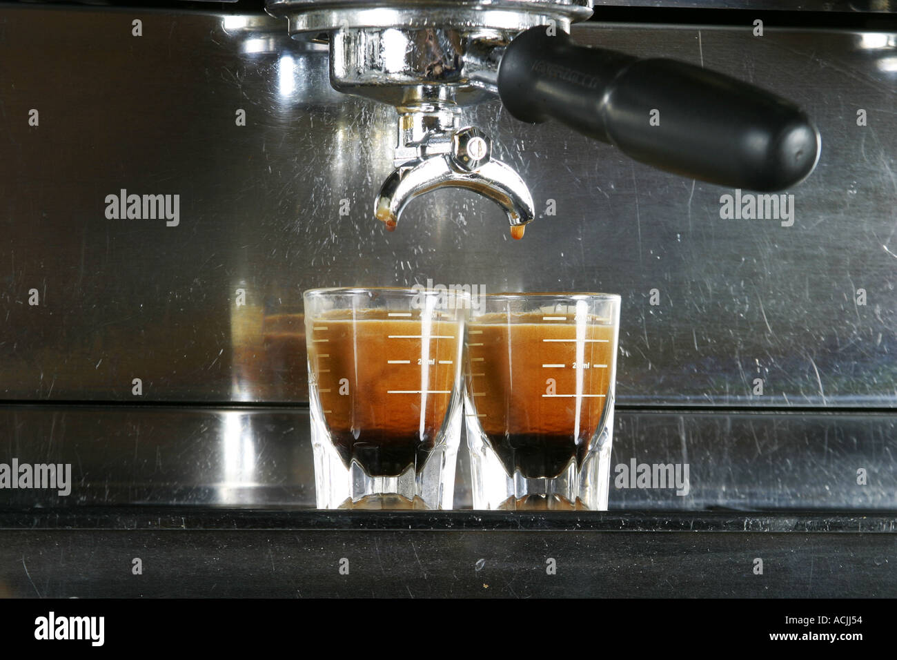 Two shots of espresso being drawn from a professional espresso machine