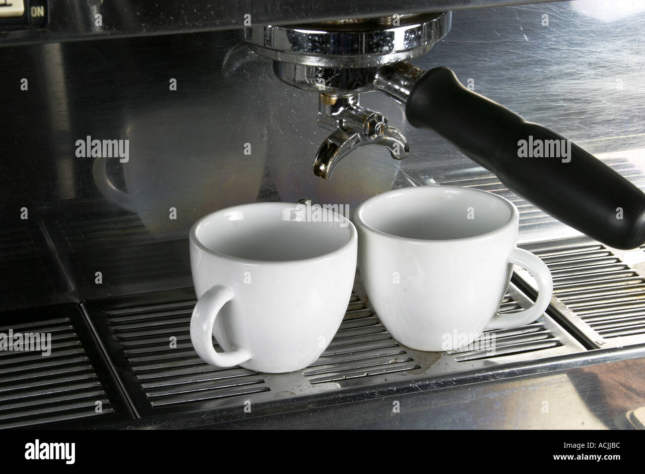 Two espresso cups getting filled in a portafilter machine Stock Photo -  Alamy