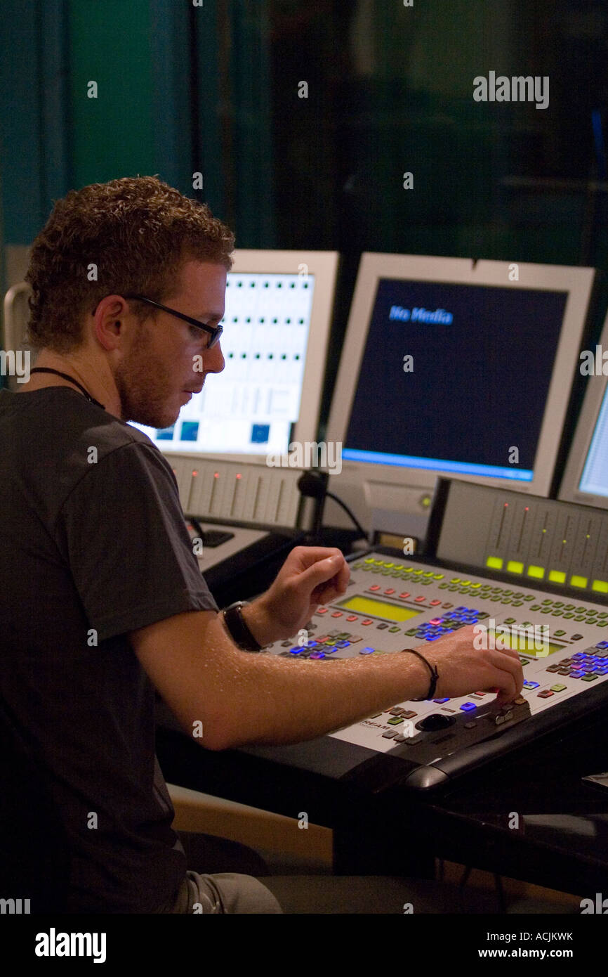 Young Man Mixing At Sound Desk Console Mixer In Recording Studio
