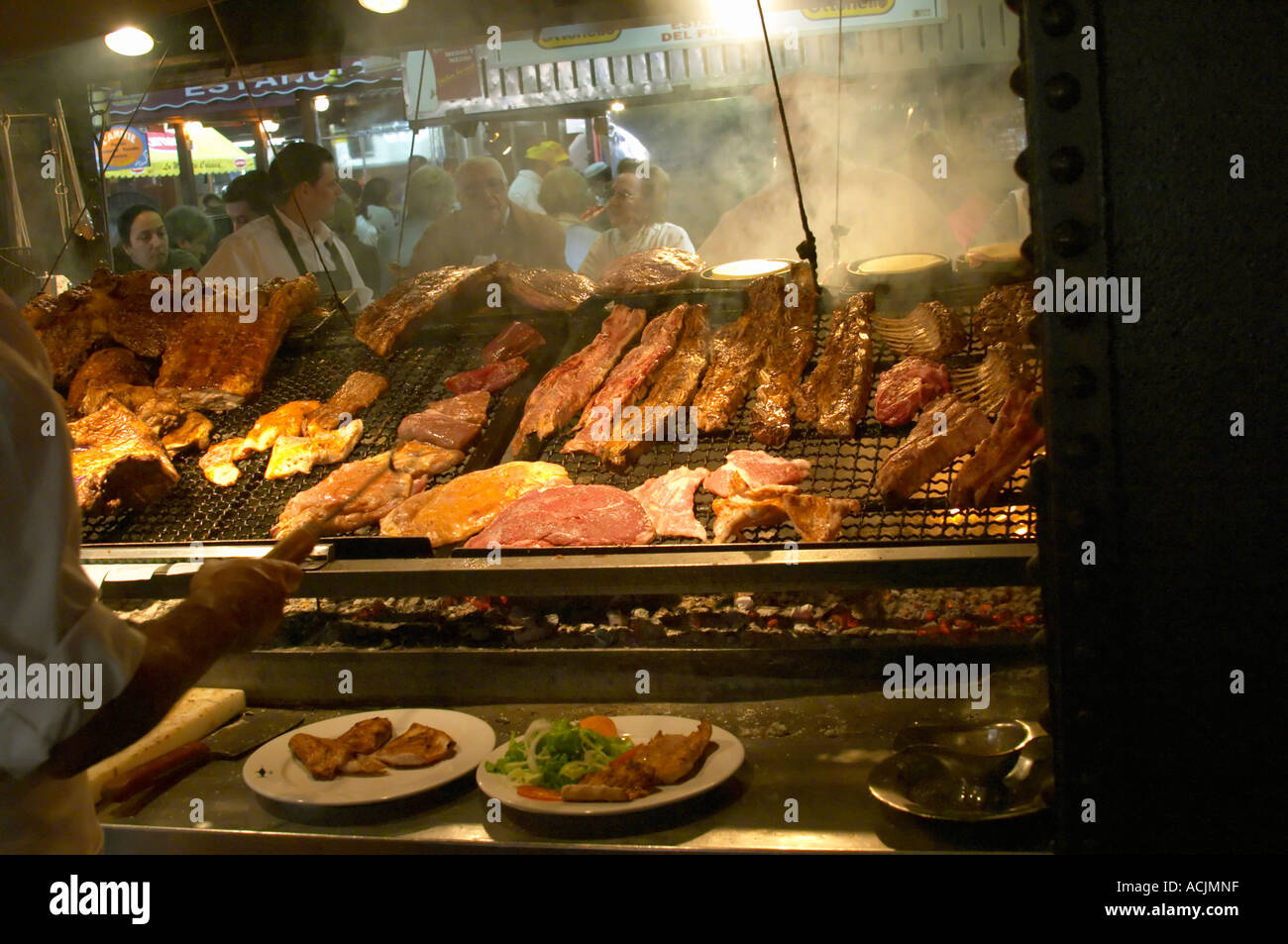 The gigantic huge charcoal grill with pieces of meat being cooked, in