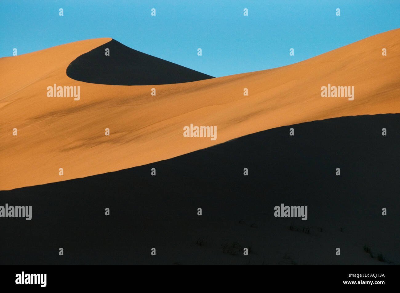 Abstract view of blue sky and shadows on a sand dune at Kelso Dunes near the Mojave Desert in California. © Craig M. Eisenberg Stock Photo