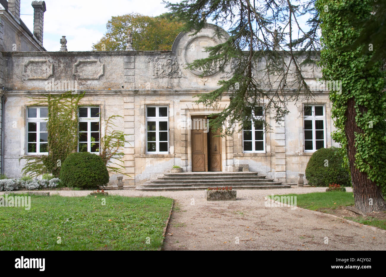 The front towards the gate and court yard of the chateau building with classic facade and stately steps leading up to the door. Stock Photo