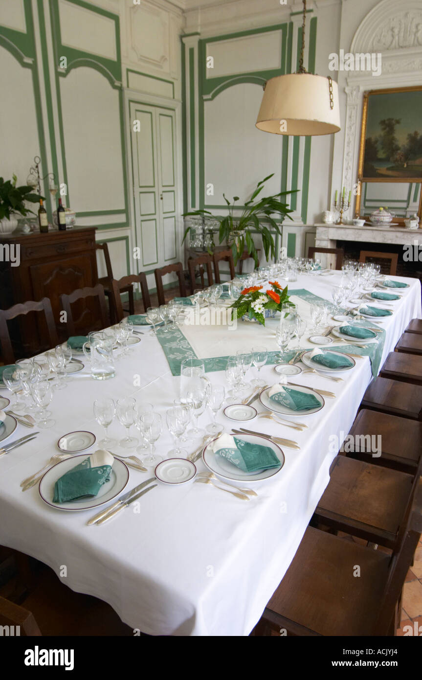 The magnificent lunch table set in traditional style with starched linen table cloth, white plates with golden decoration, silverware knives and forks, white and green linen napkins and many glasses for tasting the wine. Chateau de Cerons (Cérons) Sauternes Gironde Aquitaine France Stock Photo