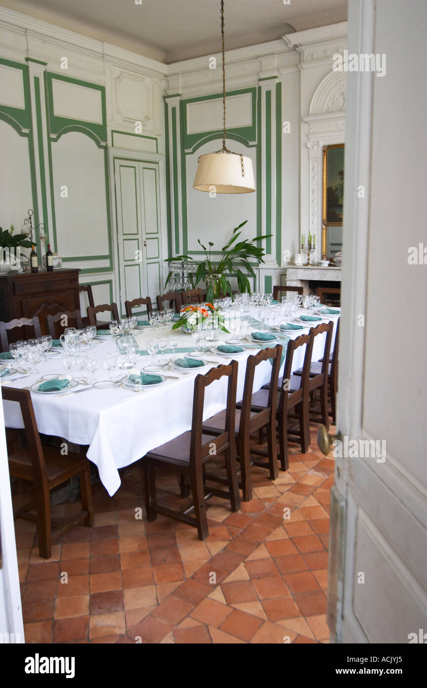 The magnificent lunch table set in traditional style with starched linen table cloth, white plates with golden decoration, silverware knives and forks, white and green linen napkins and many glasses for tasting the wine. Chateau de Cerons (Cérons) Sauternes Gironde Aquitaine France Stock Photo