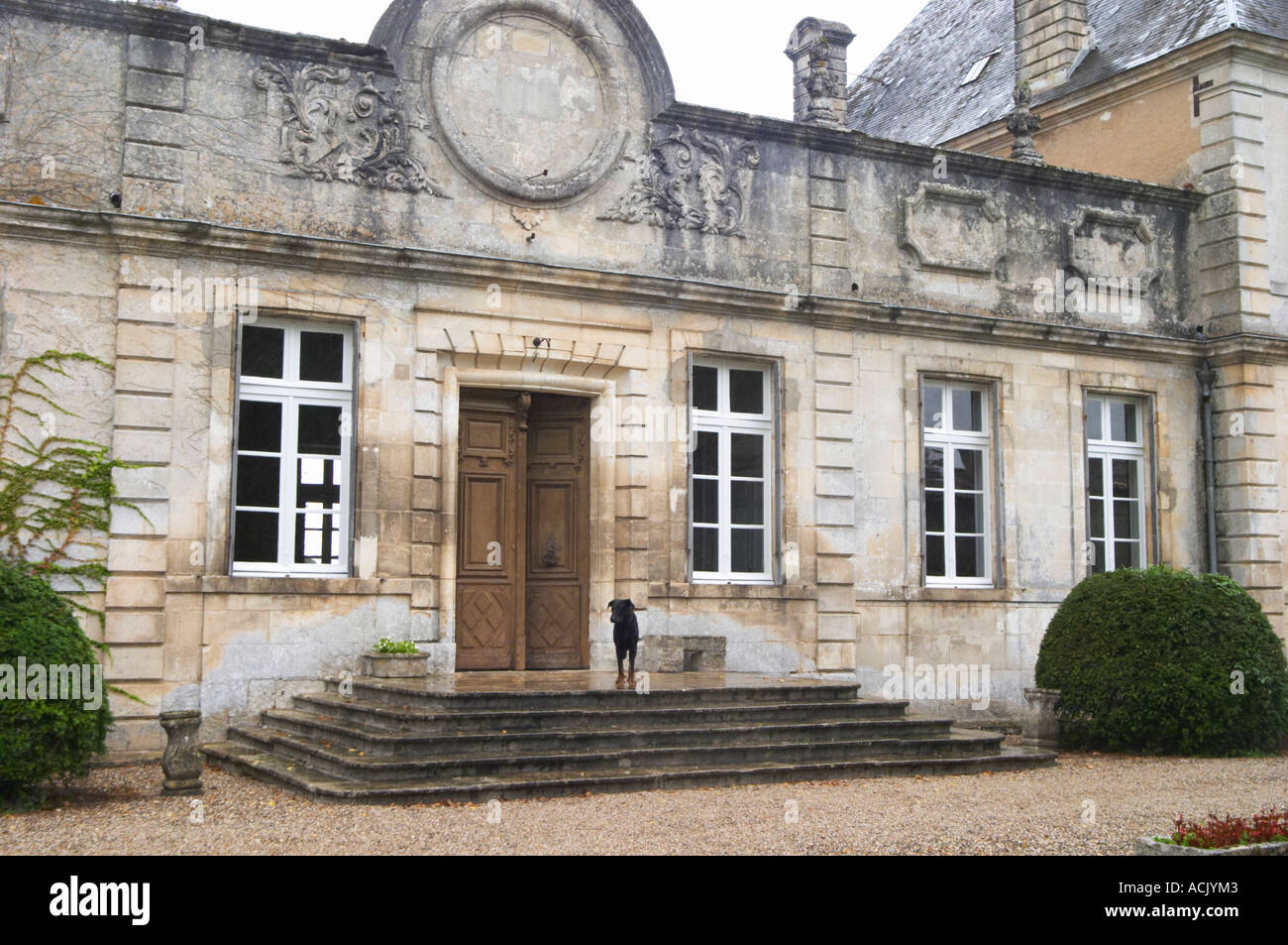 The front towards the gate and court yard of the chateau building with classic facade and stately steps leading up to the door. Stock Photo