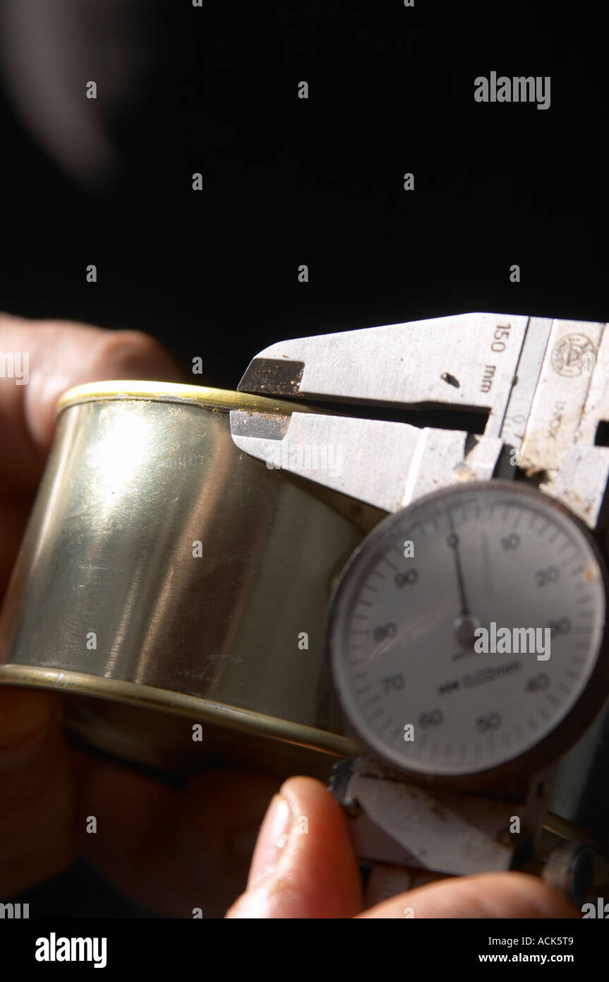 How to make foie gras duck's liver (series of images): A conserve tin can is measured with a micro-meter to verify that the can Stock Photo