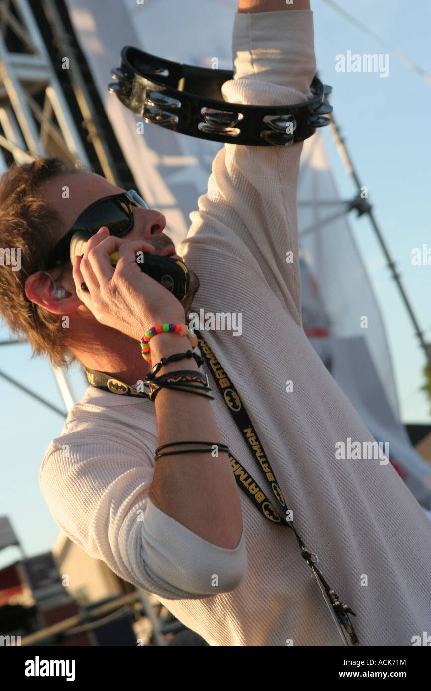 Gin Blossoms lead singer Robin Wilson waving towards the crowd and