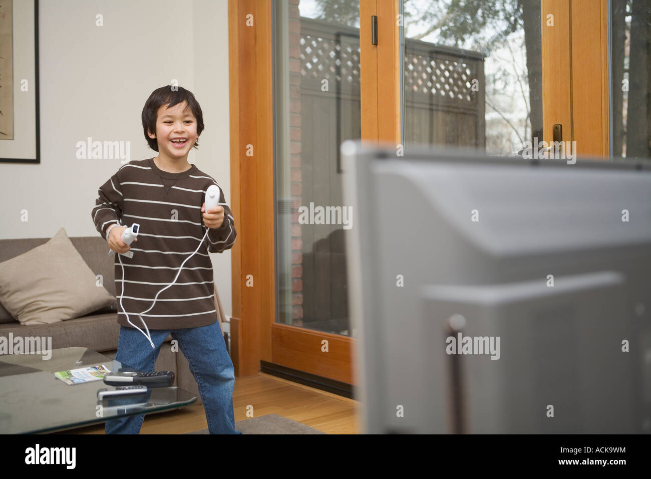 Little boy having a blast of fun, playing with the popular wireless video game Nintendo Wii. Model Released Stock Photo