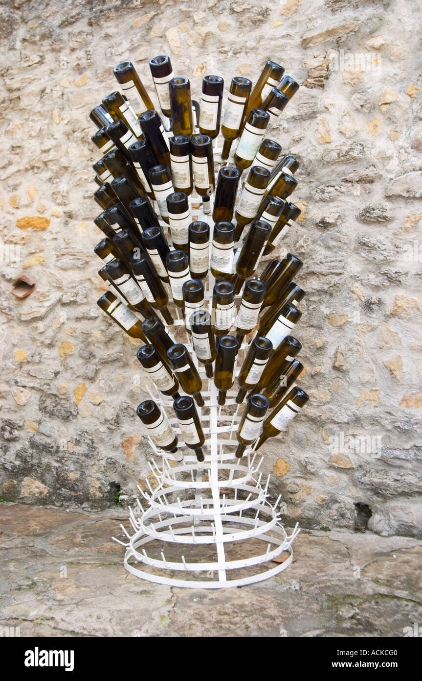 A white painted iron stand to dry bottles with bottles standing upside down, the same style of stand was used by Marcel Duchamp Stock Photo
