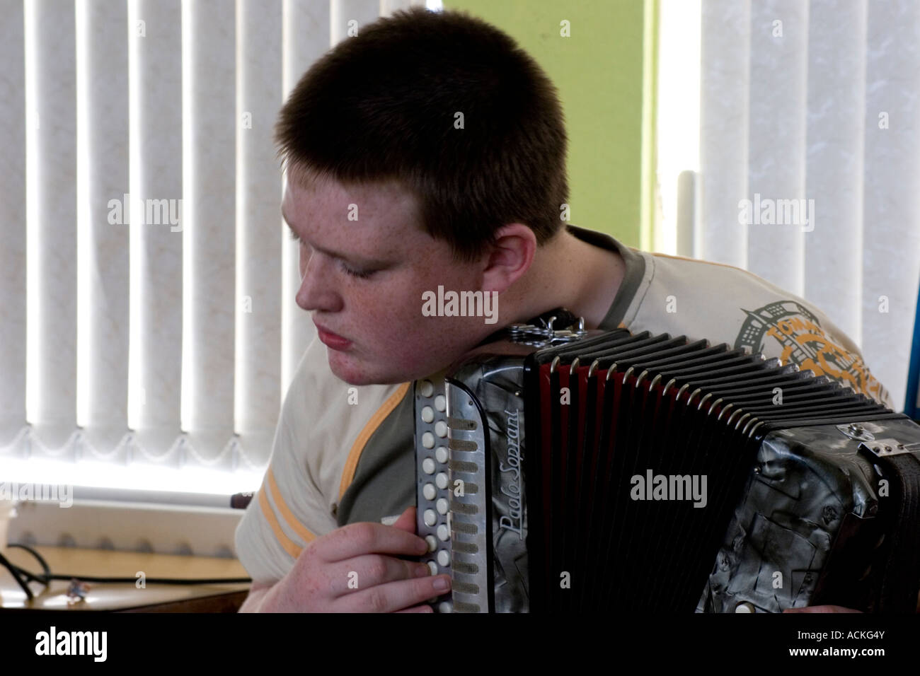 A person practicing the accordion in a quiet room with a metronome nearby