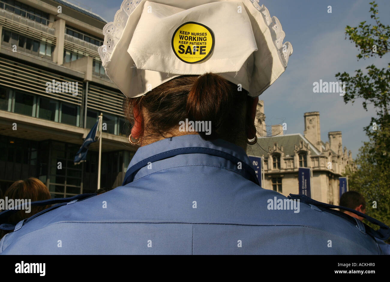 A trainee nurse at a rally in protest at changes in the NHS with a campaign sticker on her hat, Westminster, London, UK,May 2006 Stock Photo