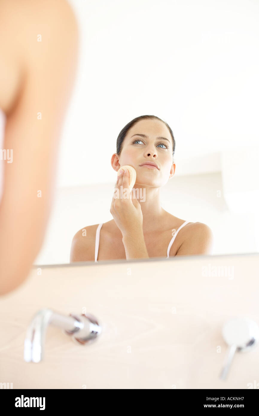 Lady Using Powder A young woman applying powder on her face Stock Photo - Alamy