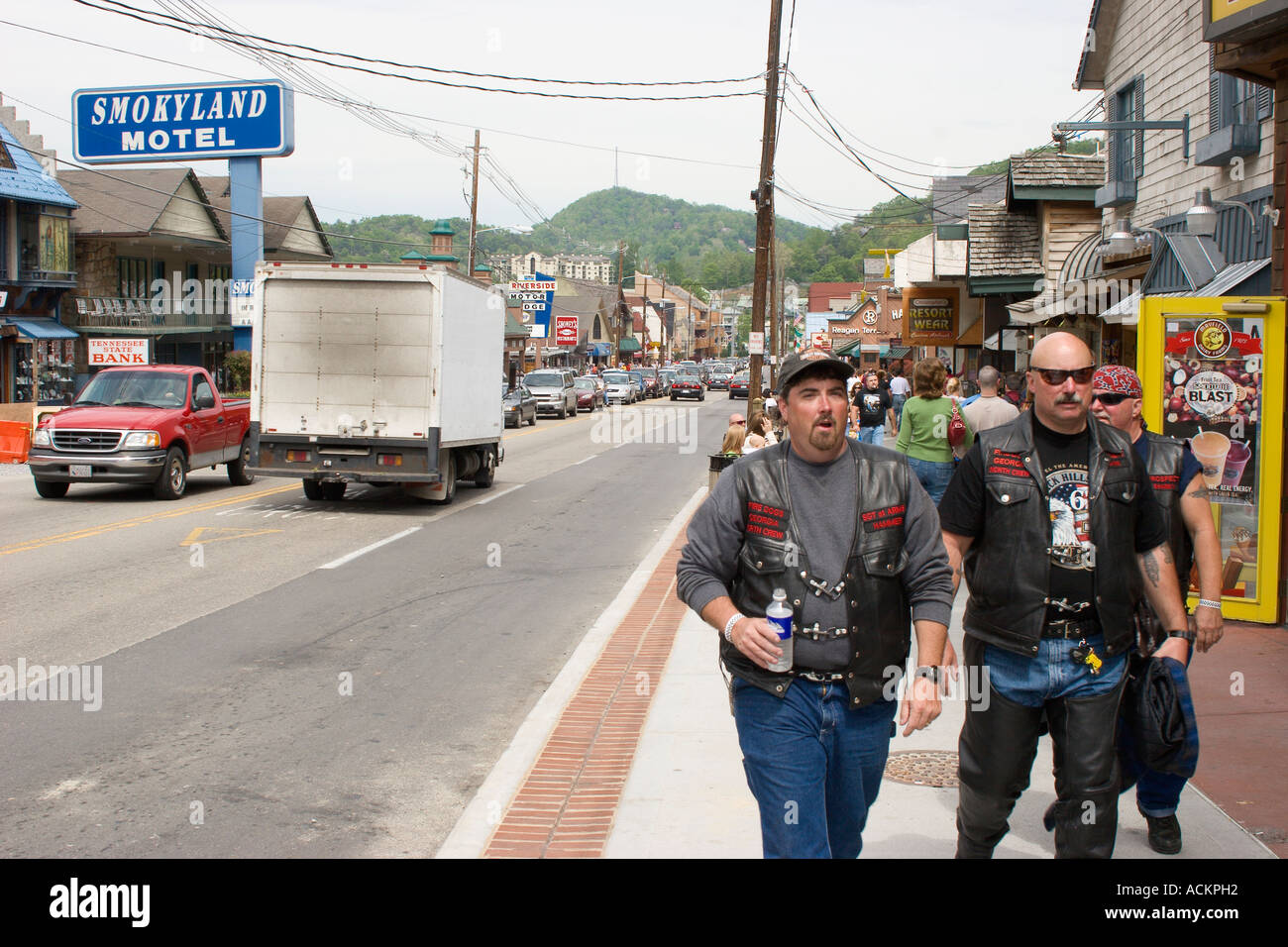 Male motorcyclists with leather vests and chaps walking along main street of downtown Gatlinburg, Tennessee, USA Stock Photo