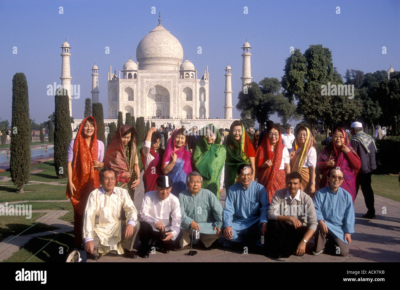 Japanese tourists posing for a photograph in front of the Taj Mahal Agra Uttar Pradesh India Stock Photo