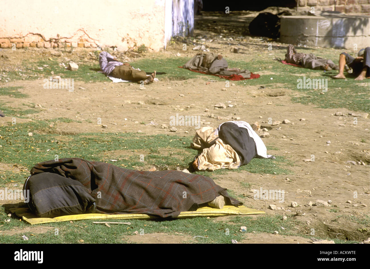 Poor people sleeping rough at the side of a street in Agra Uttar Pradesh India This is within a few miles of the Taj Mahal Stock Photo