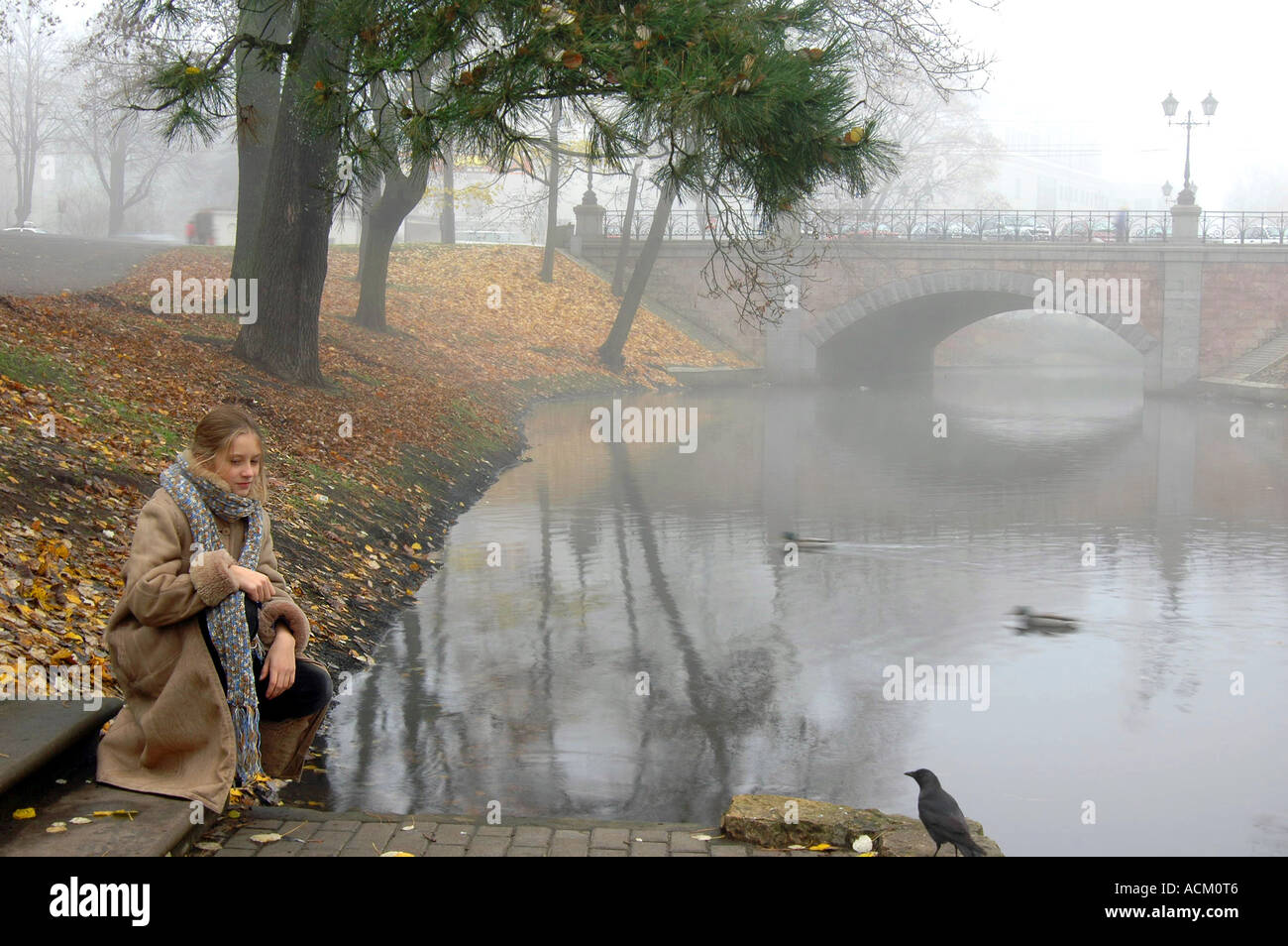 Woman sitting on the river bank Stock Photo - Alamy