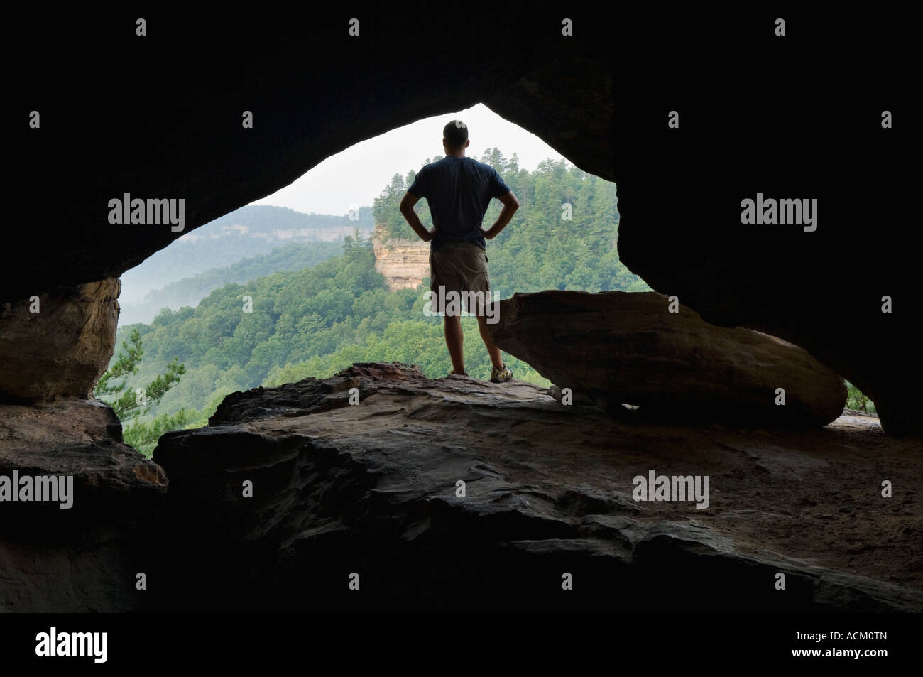 Hiker Silhouetted Against Window on Cliff Face Looking Out over Wilderness Area Red River Gorge Geological Area Kentucky Stock Photo