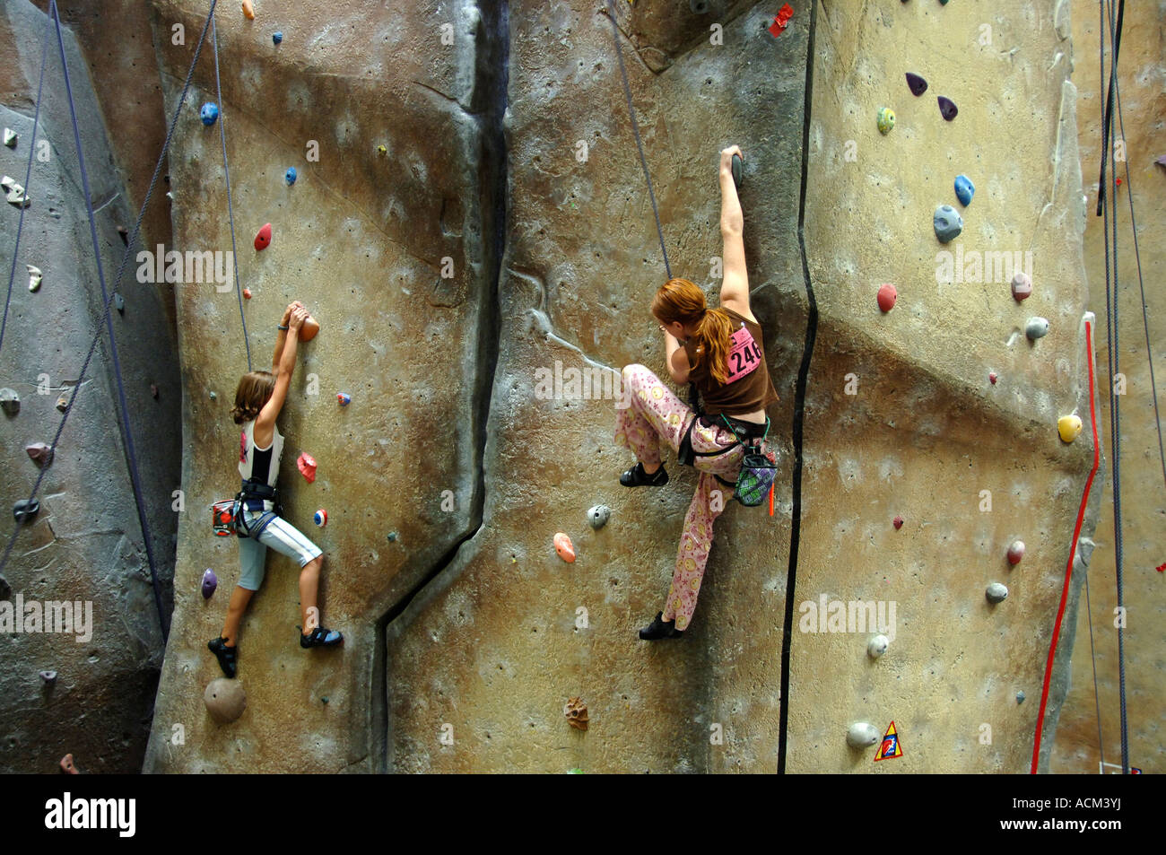 Young women climbing a wall at indoor climbing facility at a climbing