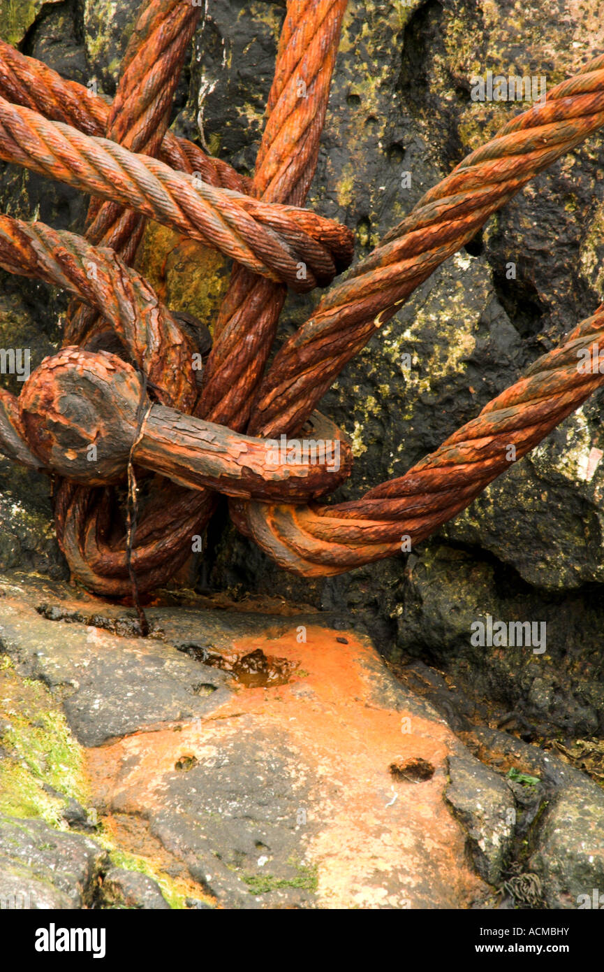 Rusty old cable left on some rocks. Stock Photo