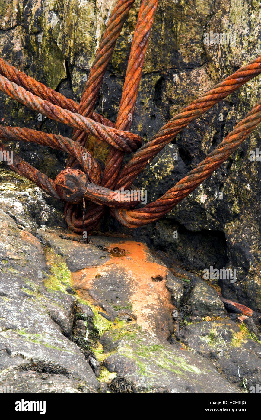 Rusty old cable left on some rocks. Stock Photo
