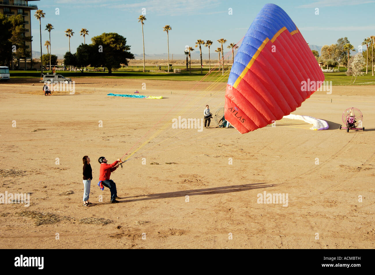 a powered paraglider pilot perpares his wing for flight at the 4th