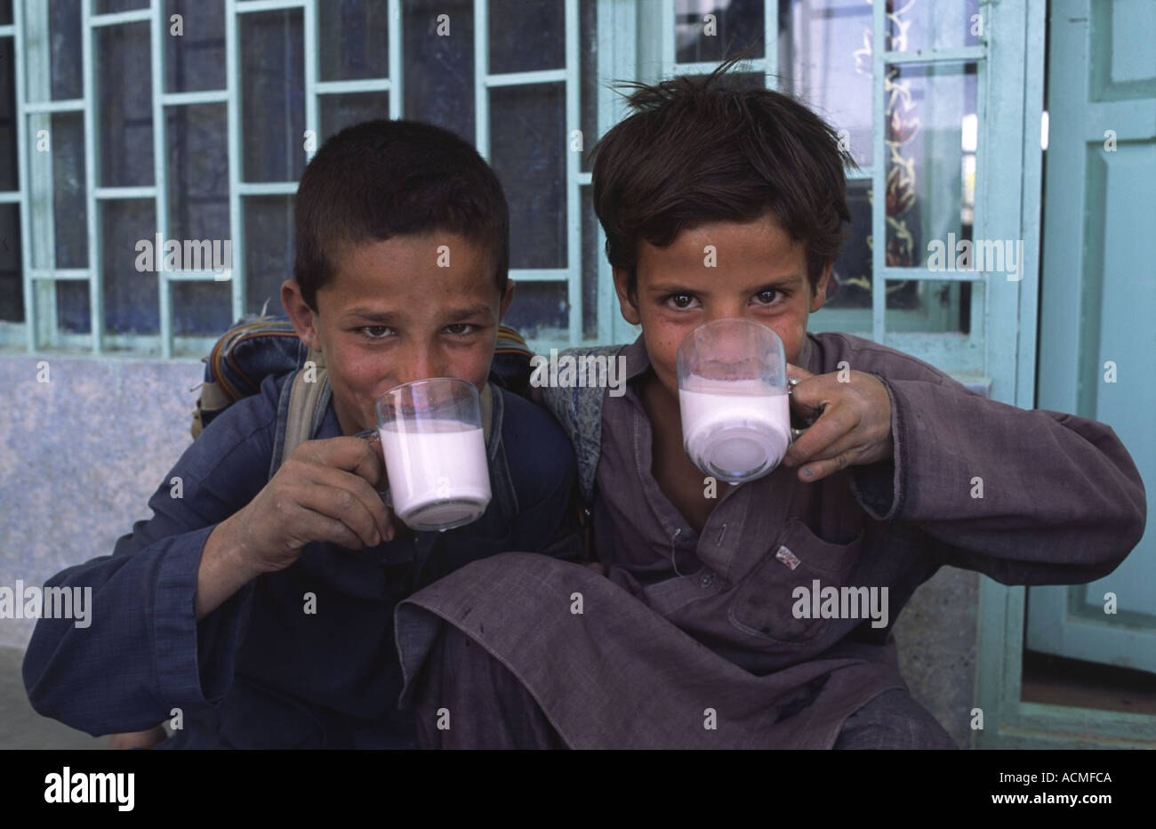 Two Afghan refugee boys enjoying a drink at an NGO funded drop in centre in Quetta Balochistan Pakistan Stock Photo