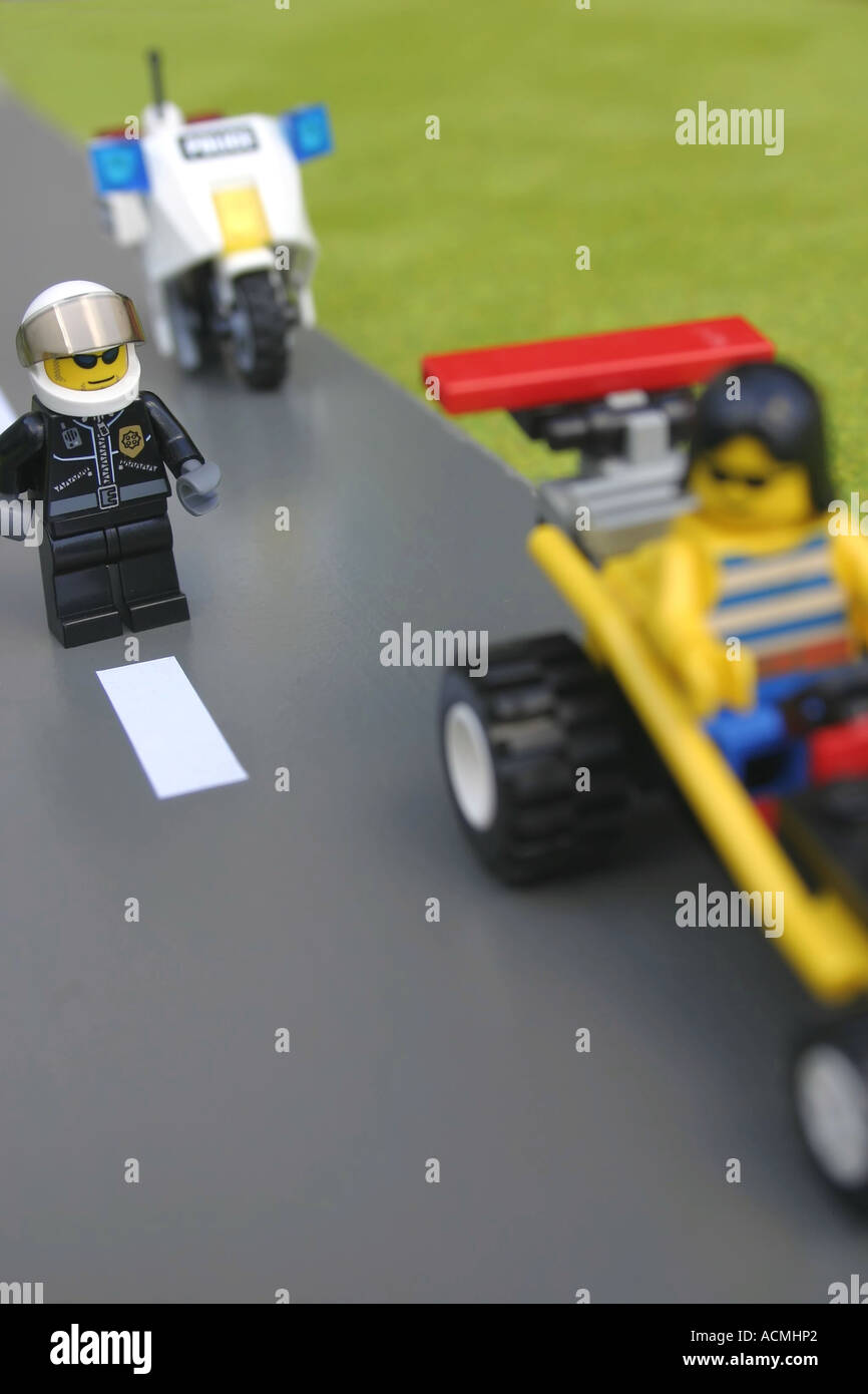 Lego police man stopping lego boy racer Stock Photo