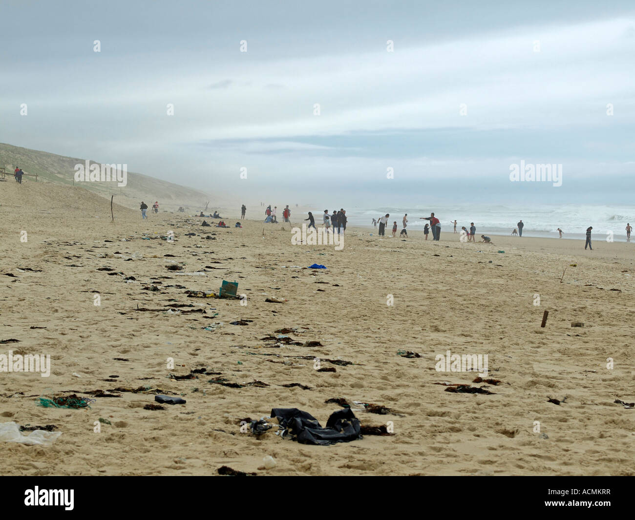 France Landes people on stormy beach with sandstorm and rubbish on sand Stock Photo