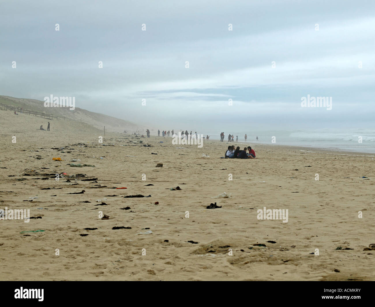 France Landes people on stormy beach with sandstorm and rubbish on sand Stock Photo