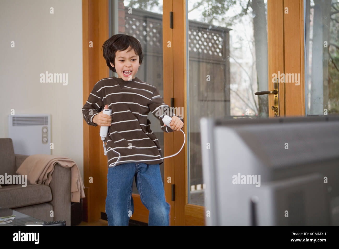 Little boy having a blast of fun, playing with the popular wireless video game Nintendo Wii. Model Released Stock Photo