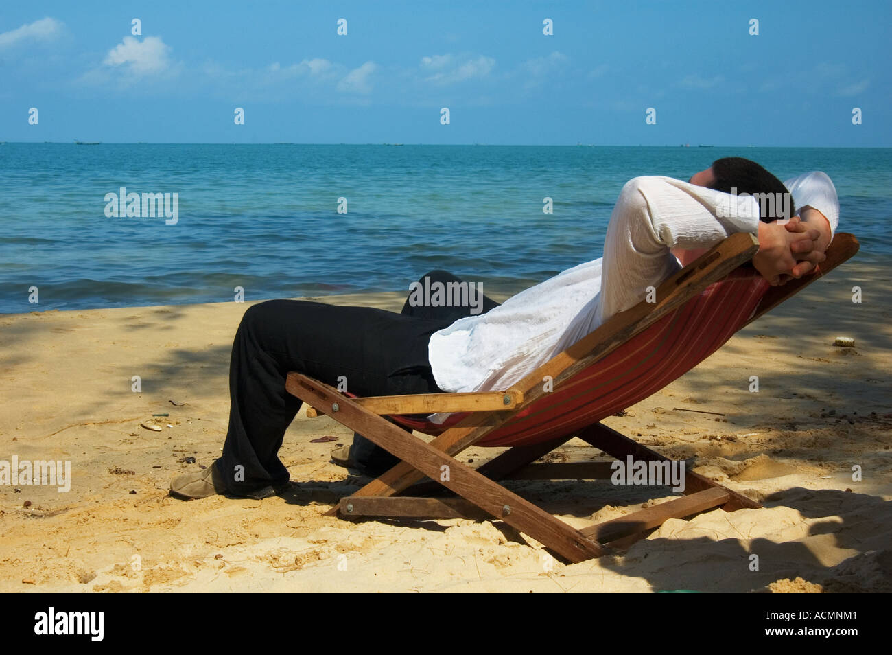 Vacationing. The man sitting in chair. Nature background Stock Photo