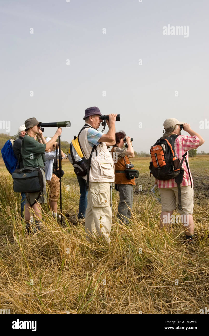 Bird watchers scan grassland mud flats near Tendaba Camp The Gambia Stock Photo