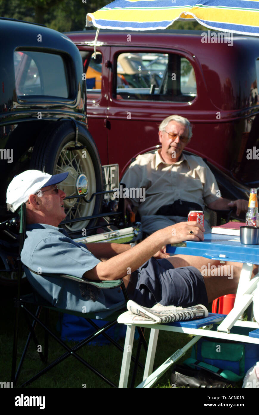 Friends sitting together at country classic car show Norwich Norfolk