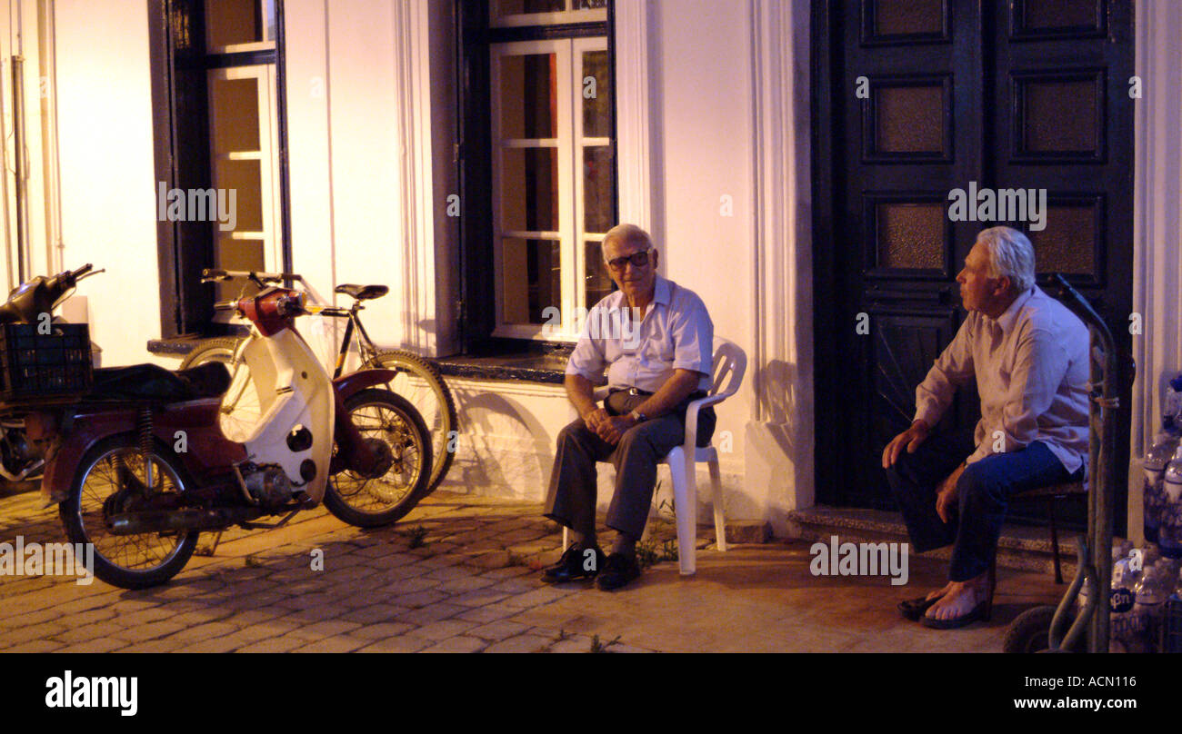 Old men sitting outside at night Skiathos Greece Stock Photo